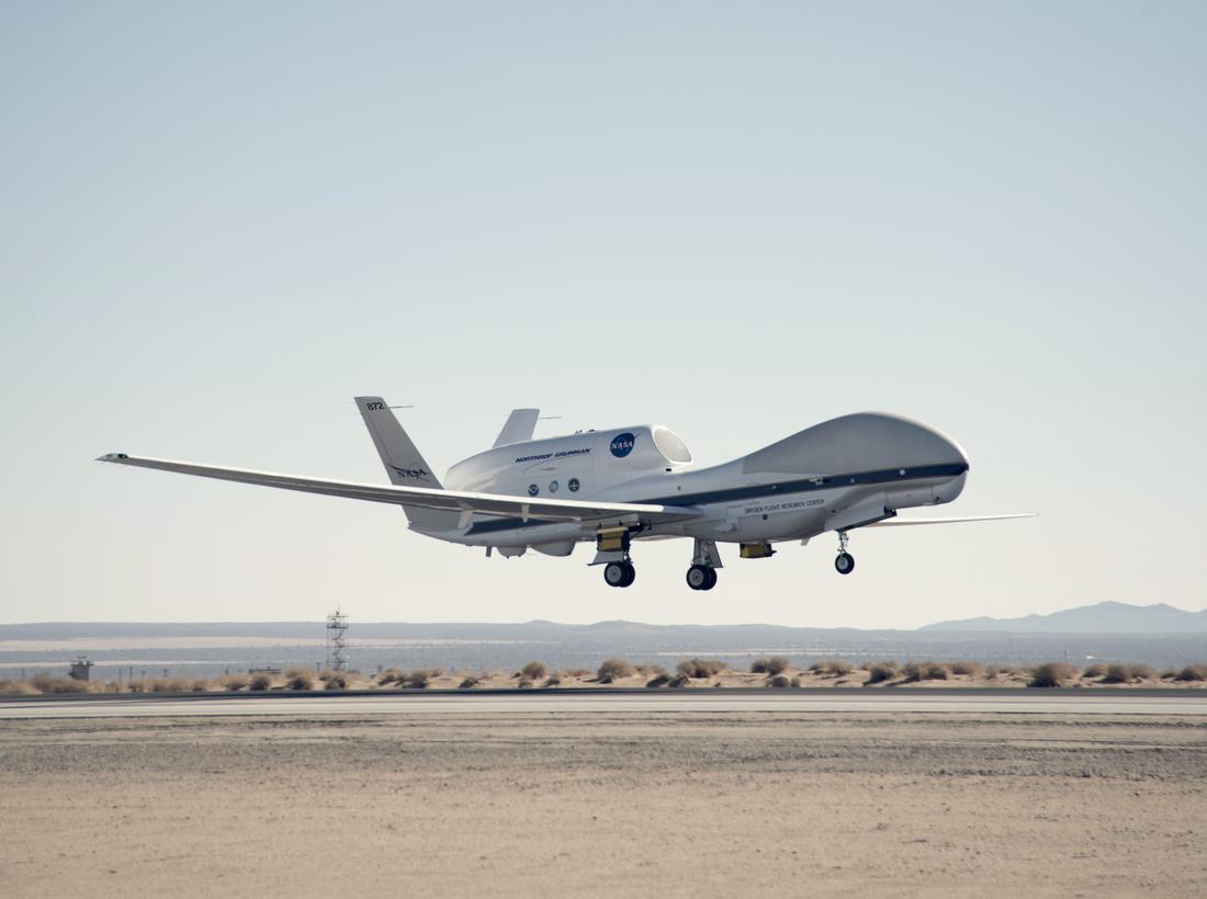 NASA's Global Hawk high-altitude research aircraft on approach over a desert runway.